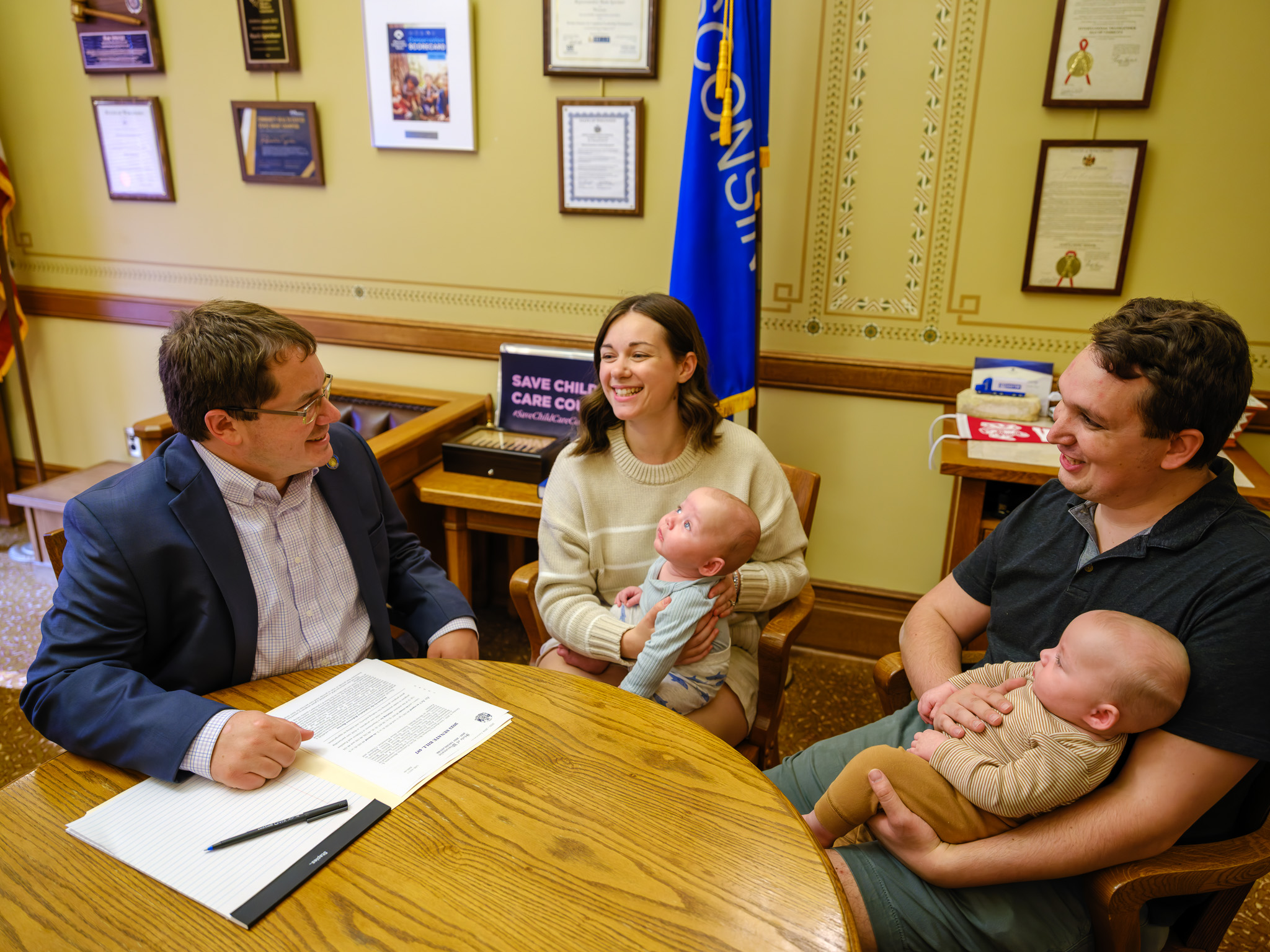 Sen. Spreitzer speaks in his Capitol office with two parents holding their babies.