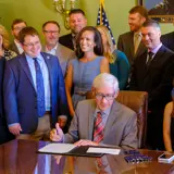 Sen. Spreitzer looks on as Governor Tony Evers signs a bill into state law. 