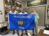 Sen. Spreitzer and Rep. Clinton Anderson deliver a Wisconsin state flag to a constituent.
