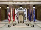 Flags, including the Wisconsin state flag and U.S. flag, are pictured in front of the West Gallery of the Capitol.