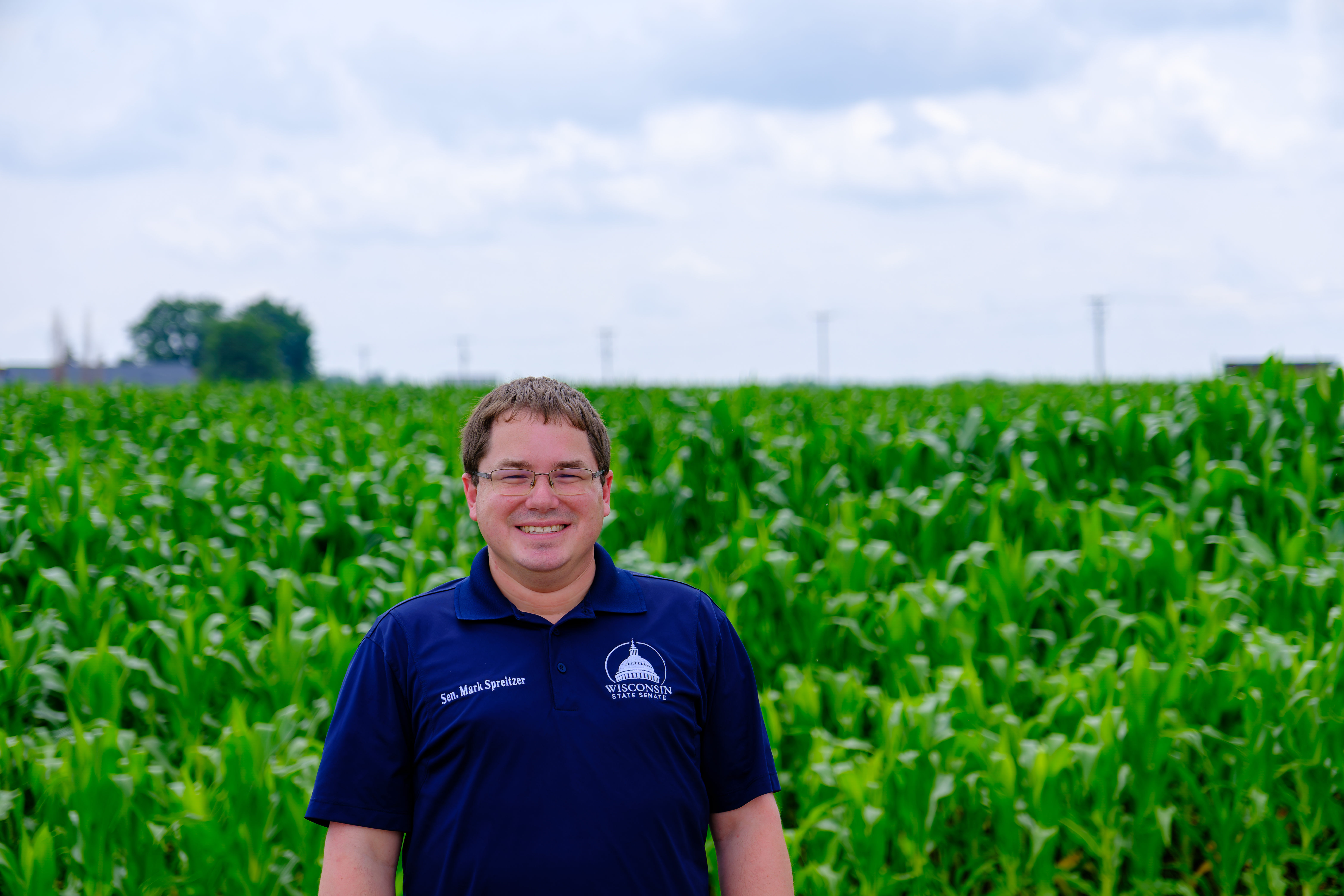 Sen. Spreitzer stands in front of a field of corn in his district.