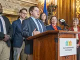 Sen. Spreitzer speaks at a press conference while legislative colleagues look on. 