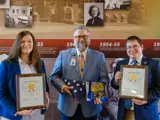 Sen. Mark Spreitzer and Rep. Jenna Jacobson present flags to Edgerton Hospital CEO Marc Augsburger. 