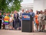 Sen. Spreitzer speaks at the Capitol flag raising for Pride Month while Governor Tony Evers, department secretaries, and members of the Legislative LGBTQ+ Caucus look on. 