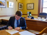 Sen. Spreitzer signs a legislative citation in his Capitol office. 