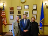 Sen. Spreitzer smiles in his Capitol office with former State Senators Judy Robson and Janis Ringhand. 