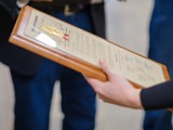 A woman holds a legislative citation presented by Sen. Spreitzer. 