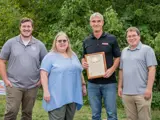 Sen. Spreitzer and Rep. Clinton Anderson present a legislative citation honoring the 150th anniversary of a local business. 