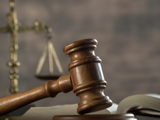 Stock photo of a gavel and scales representing the justice system.