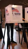 Three voting booths on a stage.