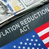 Clipart of a dollar bill, a partial American flag, and the words "Inflation Reduction Act. 