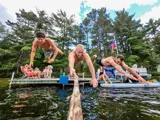 Action photo of people jumping into a lake from a dock with a go-pro.