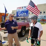 Senator Smith talking with a constituent on a bike during one of his Stop and Talk sessions
