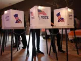 Three voting booths on a stage.