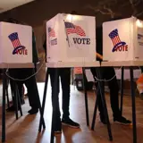 Three voting booths on a stage.