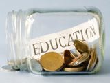 Jar on its side filled with coins and a slip of paper with education written on it.